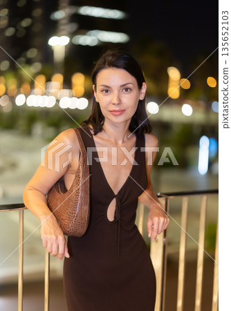 At night, smiling girl walks around old city district Barceloneta, in vicinage of Citadel Park At night, smiling girl walks around old city district Barceloneta, in vicinage of Citadel Park 135652103