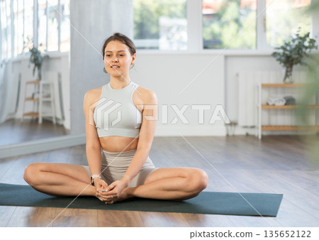 Young woman practicing yoga in butterfly pose 135652122
