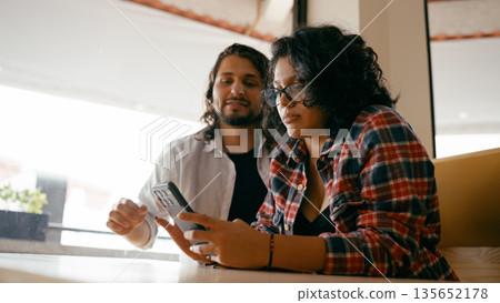 Young couple enjoying shared content on smartphone Young couple enjoying shared content on smartphone 135652178