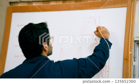 Woodworker planning carpentry project on whiteboard Woodworker planning carpentry project on whiteboard 135652360