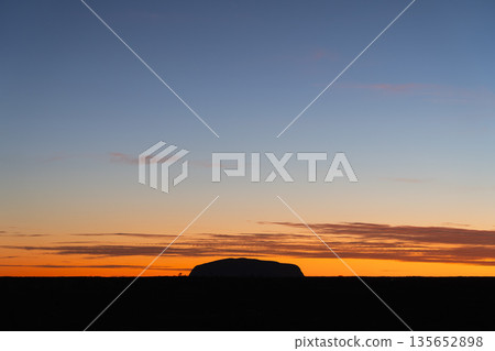 Iconic Uluru silhouette against horizontal sunrise sky, Australia Iconic Uluru silhouette against horizontal sunrise sky, Australia 135652898