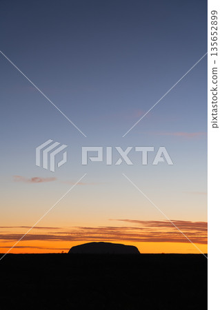 Iconic Uluru silhouette against layered sunrise sky, Australia Iconic Uluru silhouette against layered sunrise sky, Australia 135652899