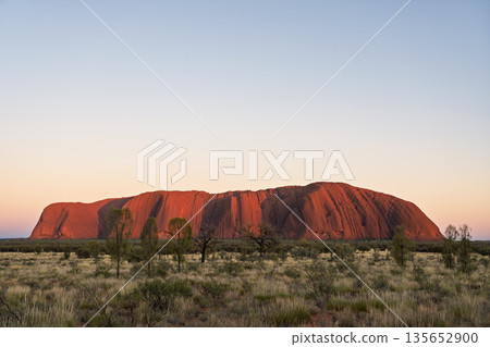 Iconic Uluru monolith glowing red at sunset, Australia 135652900