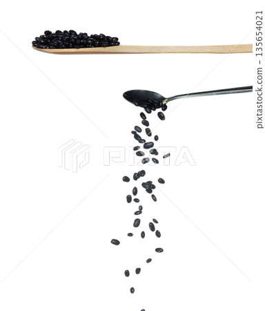 Black Bean fall, black grain beans explode abstract cloud fly from silver spoon. Beautiful complete seed pea bean, food object design. Selective focus freeze shot white background isolated 135654021