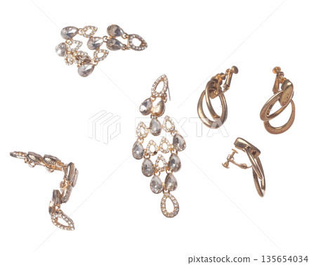 Fashion gold Earrings with beautiful work detail is value. Luxury golden earring is fashion trend and fly in air. White background isolated 135654034
