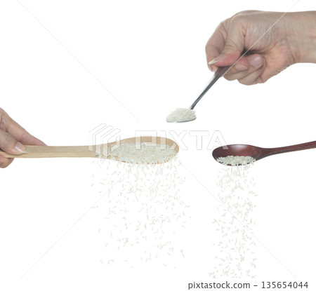 Japanese Rice fall, white grain rices pouring down abstract cloud fly from spoon. Beautiful complete seed rice in air, food object design. Selective focus freeze shot white background isolated 135654044