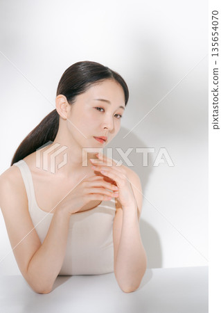 A young lady hitting his cheek 135654070