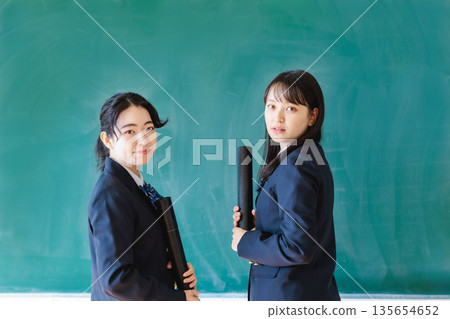 女學生拿著文憑站在黑板前 女學生拿著文憑站在黑板前 135654652