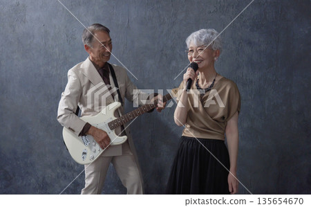 資深樂手：男吉他手與女歌手，黑色背景 135654670