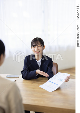 Young businesswoman chatting with a client Young businesswoman chatting with a client 135655119