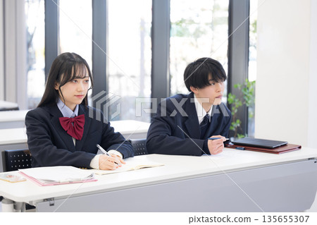 A classroom scene where high school boys and girls take notes at school, cram school, or prep school and are actively engaged in class. Image of university entrance exams, etc. A classroom scene where high school boys and girls take notes at school, cram school, or prep school and are actively engaged in class. Image of university entrance exams, etc. 135655307