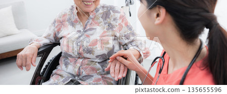 Nurses supporting elderly people in wheelchairs in hospitals and home care facilities, holding hands and looking at each other, faceless image Nurses supporting elderly people in wheelchairs in hospitals and home care facilities, holding hands and looking at each other, faceless image 135655596