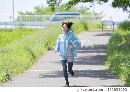 A woman in her 40s running outdoors A woman in her 40s running outdoors 135655660