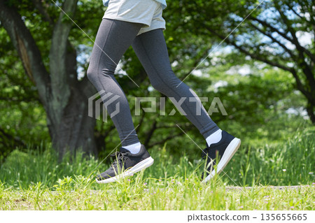 Woman in her 40s running outdoors, no face Woman in her 40s running outdoors, no face 135655665