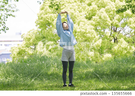 A woman in her 40s doing warm-up exercises outdoors A woman in her 40s doing warm-up exercises outdoors 135655666