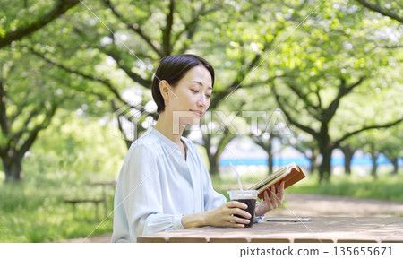 Woman reading outdoors Woman reading outdoors 135655671