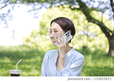 一名女子在戶外用智慧型手機打電話 135655673