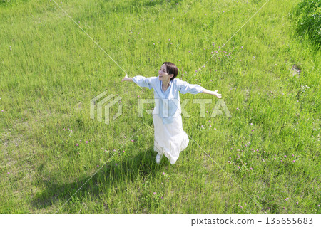 Aerial view of a woman taking a deep breath in the field 135655683