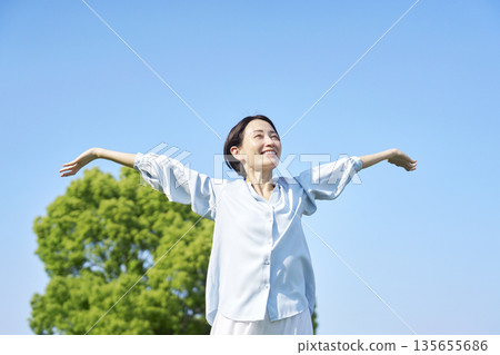 Woman taking a deep breath outdoors Woman taking a deep breath outdoors 135655686