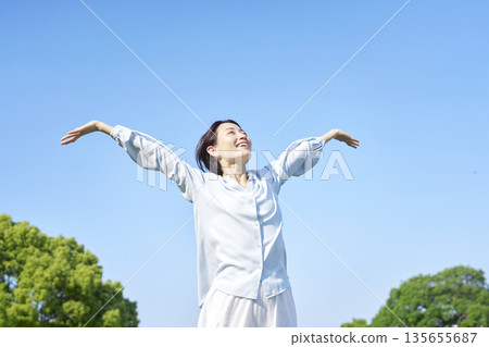 Woman taking a deep breath outdoors Woman taking a deep breath outdoors 135655687