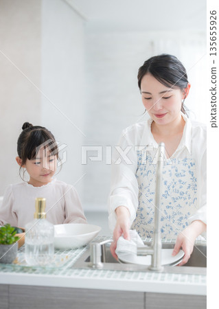 Parents and children cooking and washing dishes in the kitchen, helping mom like they're playing house Parents and children cooking and washing dishes in the kitchen, helping mom like they're playing house 135655926