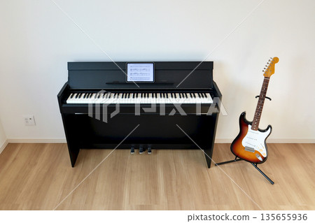 客廳裡擺放著一把電吉他和一架數位鋼琴，樂譜架上放著一台平板電腦。 135655936