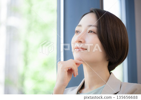 一位女商人倚窗沉思，擔憂自己的事業，她該如何考慮換工作？ 135656688