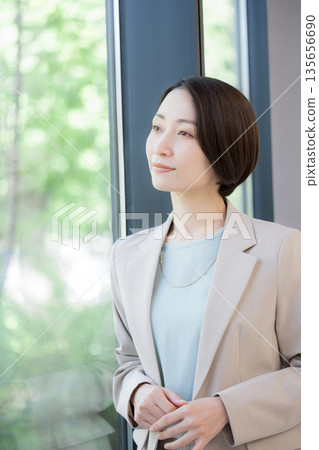 一位女商人倚窗沉思,擔憂自己的事業,她該如何考慮換工作? 一位女商人倚窗沉思,擔憂自己的事業,她該如何考慮換工作? 135656690