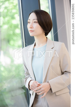 一位女商人倚窗沉思,擔憂自己的事業,她該如何考慮換工作? 一位女商人倚窗沉思,擔憂自己的事業,她該如何考慮換工作? 135656691