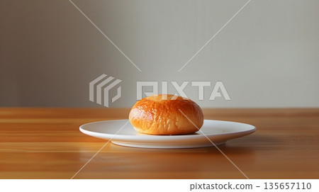 白色盤子和圓形麵包放在木桌上。 135657110