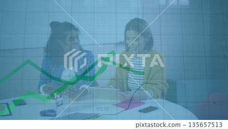 Collaborating two coworkers reviewing documents in meeting room, with tablet papers and graph over Collaborating two coworkers reviewing documents in meeting room, with tablet papers and graph over 135657513