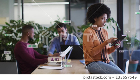 Colleagues in business attire collaborating at office table, with devices and documents, copy space 135657549