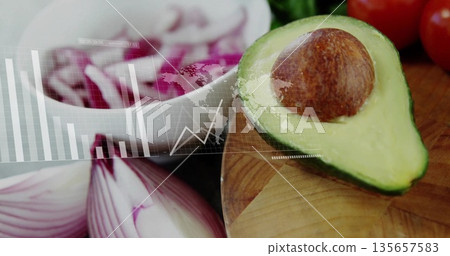 Displaying halved avocado on kitchen cutting board with red onion slices and data overlay 135657583