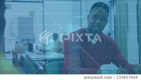 Leading Black man in red sweater showing charts in conference room, with digital graph overlay 135657604