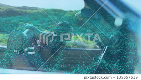 Sunglassed Indian woman leaning through lowered door on road, with point-cloud overlay, copy space 135657619