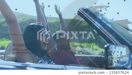 Driving convertible laughing duo wearing sunglasses throwing arms on country road, with seat belts Driving convertible laughing duo wearing sunglasses throwing arms on country road, with seat belts 135657624