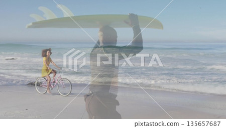Wetsuit-clad man carrying surfboard, yellow-dress woman pedaling bicycle on beach, ocean waves Wetsuit-clad man carrying surfboard, yellow-dress woman pedaling bicycle on beach, ocean waves 135657687