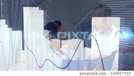 Doctor wearing stethoscope examining digital chart overlays in exam room, nurse holding file folder 135657707