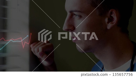 Leaning doctor in scrubs with stethoscope gazing through blinds in clinic with graph overlay 135657756