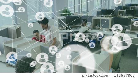 Collaborating five office colleagues reviewing desktop monitors in open office, with smartphone 135657863