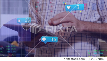 Holding tablet man wearing plaid shirt tracking floating social metrics and line graphs in office Holding tablet man wearing plaid shirt tracking floating social metrics and line graphs in office 135657882