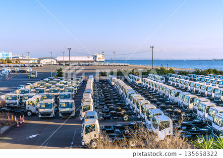 Yokohama cityscape in Japan. Japanese economy...a row of trucks. Honmoku Pier is in the back right. New reclamation work is underway. Yokohama cityscape in Japan. Japanese economy...a row of trucks. Honmoku Pier is in the back right. New reclamation work is underway. 135658322