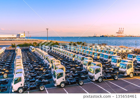 Yokohama cityscape in Japan. Japanese economy...a row of trucks. Honmoku Pier is in the back right. New reclamation work is underway. Yokohama cityscape in Japan. Japanese economy...a row of trucks. Honmoku Pier is in the back right. New reclamation work is underway. 135658461
