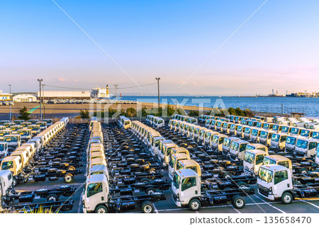 日本橫濱城市景觀。日本經濟……一排卡車。本牧碼頭位於右後方。新的填海工程正在進行中。 日本橫濱城市景觀。日本經濟……一排卡車。本牧碼頭位於右後方。新的填海工程正在進行中。 135658470