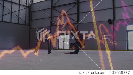 Stretching contortionist bending on chair and forearms in industrial hall with neon graph overlays Stretching contortionist bending on chair and forearms in industrial hall with neon graph overlays 135658877