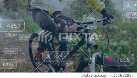 Riding cyclist wearing yellow cycling jacket on mountain bike along forest trail, with social icons 135658883