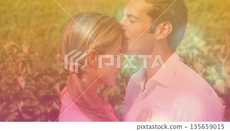 Embracing couple exchanging forehead kiss among sunlit grapevines during golden hour, warm light Embracing couple exchanging forehead kiss among sunlit grapevines during golden hour, warm light 135659015