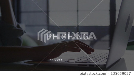 Hovering hand typing on laptop keyboard at home office desk, with overlay text PHISHING 135659037