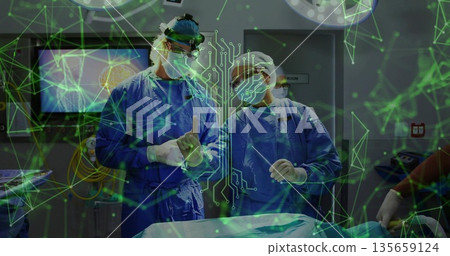 Two surgeons wearing blue scrubs performing brain surgery in operating theater, using AR overlay 135659124