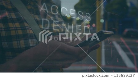 Man in shirt holding smartphone and reading ACCESS DENIED graphic on sidewalk, with crossbody strap 135659127